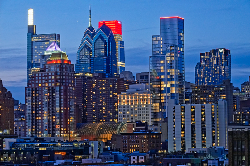 The lights of downtown Philadelphia come up as the sun goes down on a day in late March 2023.