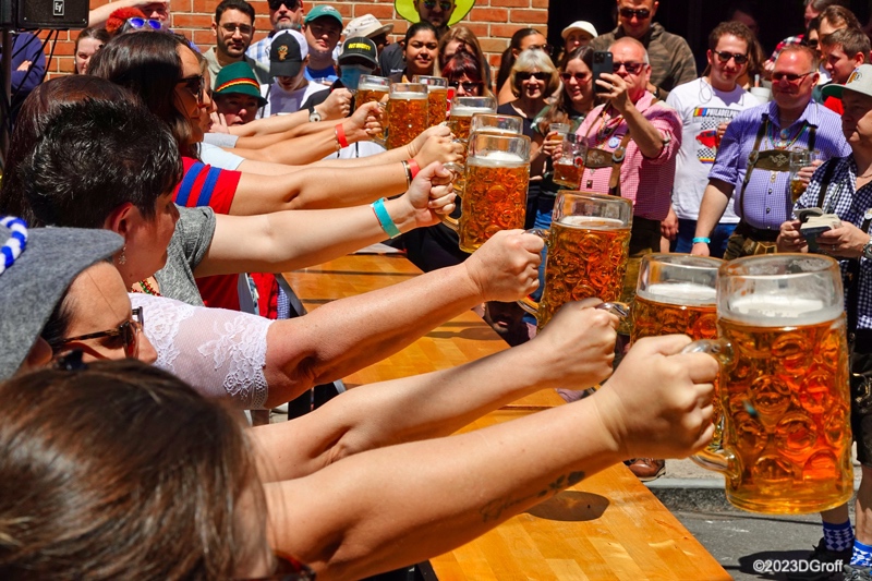 "Lady Lifters" compete to see who can hold out a full stein longest during the Brauhaus Schmitz Maifest on South Street in Philadelphia on May 6, 2023. 